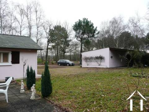 This is a view from the terrace that leads from the master bedroom. From here you look out onto the back garden, woodland and also the the property's double garage and car port.
