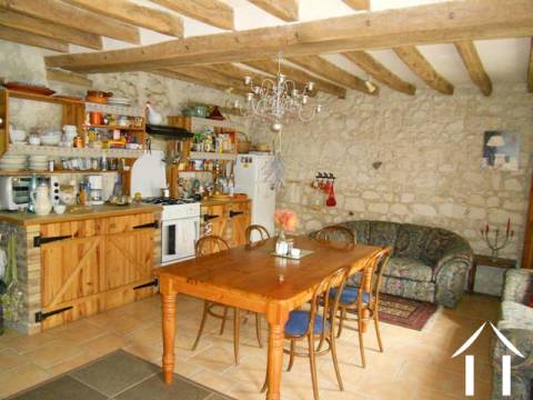 The sejour (or living room) with its corner kitchen. This room is light, airy and has lots of character. It also has an efficient wood burning stove (not seen in picture). From this room, the back door opens into a covered veranda-style walkthorugh, that has steps down to the cave and provides access into a small courtyard between the house and the outbuilding. 