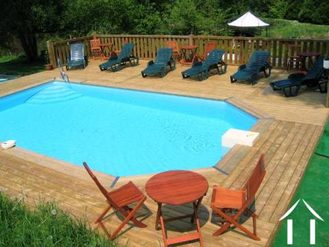 The heated swimming pool and sun deck, which overlooks the second of the lakes. 