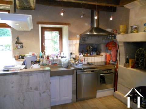 The kitchen is open plan and has a feature stone sink and worksurface area - it looks into the the sejour.
