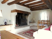 This is the lounge area of the gîte with its large feature fireplace and exposed oak beams.