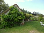 Part of the garden with the covered dining terrace and large, converted piggery.