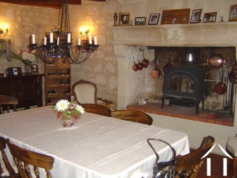 The front door opens into this large room (dining room) with its feature fireplace, wood burning stove and tons of character: terra cotta tiled floor, exposed stone walls and oak beams. This room is connected to the kitchen and also includes the staircase to the First Floor.