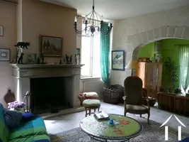 The lounge area with high ceilings, feature fireplace and tiled floor. This is a commanding room (24m2) which has its own TV and music alcove (17m2) seen through the archway.