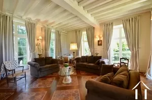 grand salon, with windows on three sides, and stone burgundy fire place