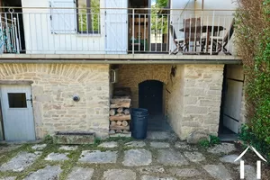 Sous la terrase, accès à la cave (à g.), au garage (milieu), au rangement pour outils de jardin (à dr.)