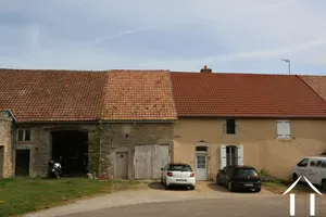 Grange avec porte de garage blanche et tuile orange claire