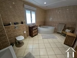 Bathroom featuring a corner bath, shower, wash basin, and toilet