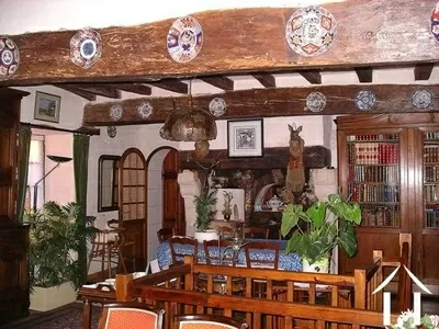 Throughout this 500 year-old property there are lots of original features and tons of character including exposed oak beams, stone walls, impressive fireplaces and terra cotta tiled floors. This picture shows the dining room; beyond this is the kitchen. 