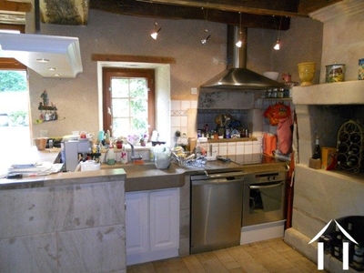 The kitchen is open plan and has a feature stone sink and worksurface area - it looks into the the sejour.