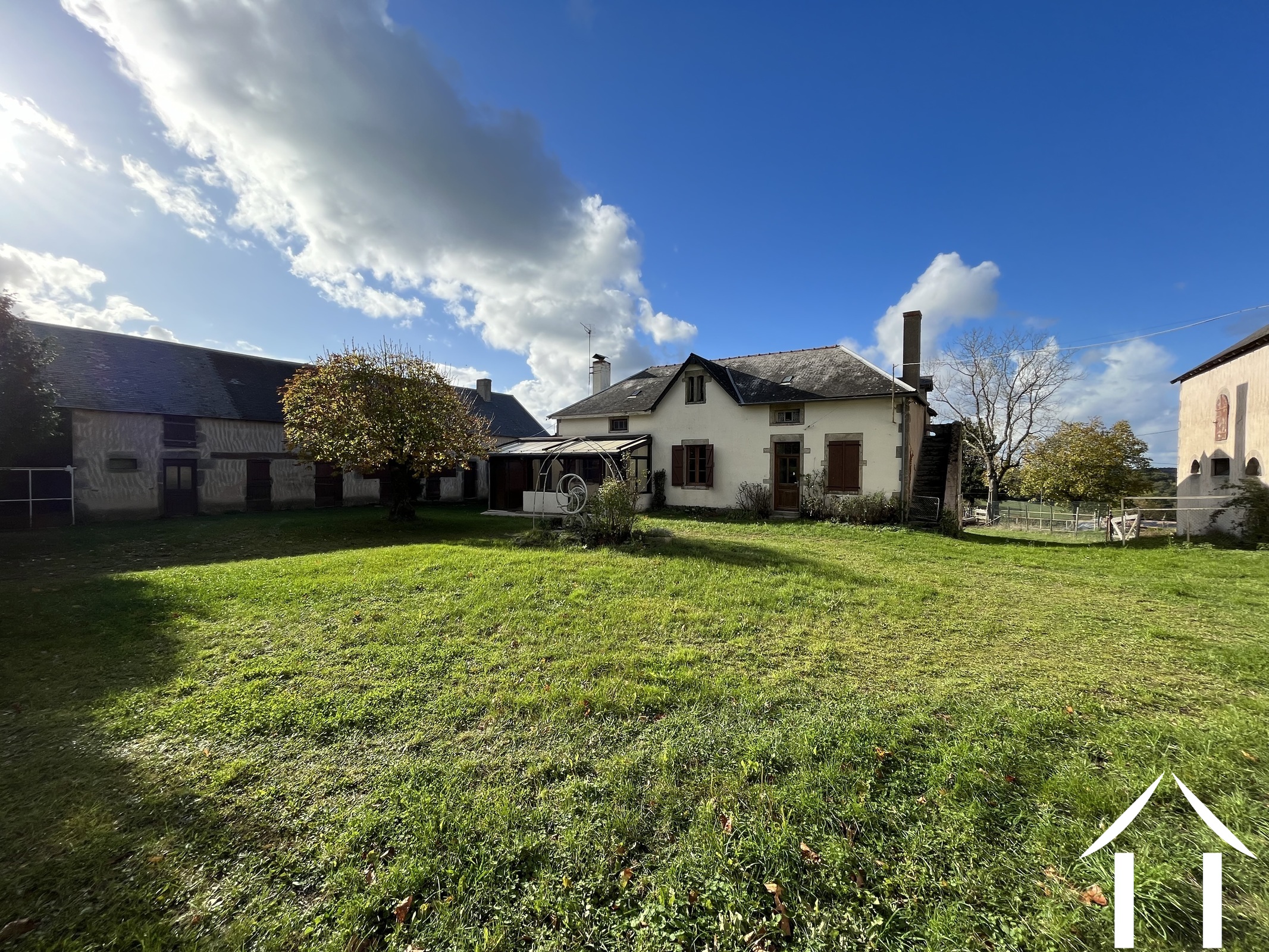 Country side house with two large barns.